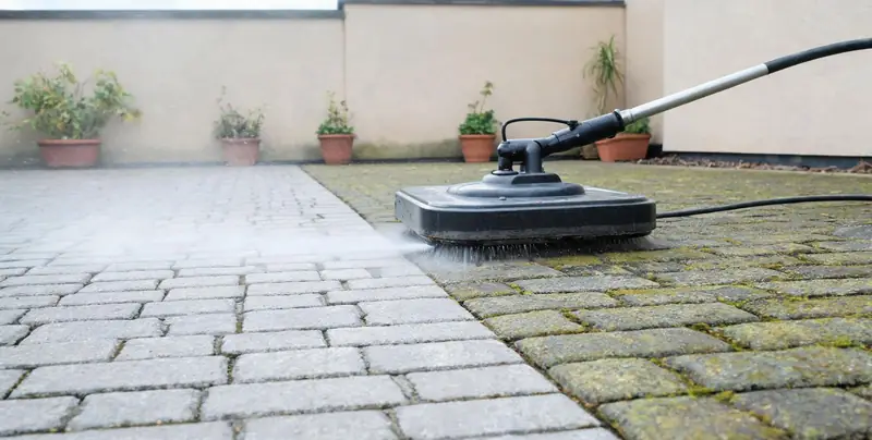 Innenhof wird mit dem Flächenreiniger gesäubert, gereinigter Streifen deutlich sichtbar